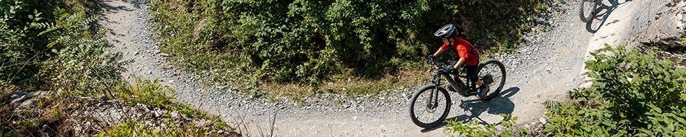 Kids riding specialized bike around a sweeping turn wearing a helmet